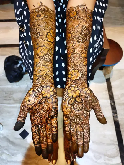 A full-coverage bridal design with a focus on floral motifs. The patterns are dense and rich, perfect for a wedding.