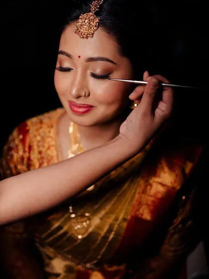 This getting-ready shot shows the final touches of eyeliner application. A sharp, clean line is key to defining the eyes and completing a classic bridal look.