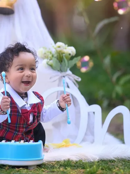 Making music to celebrate turning one. This playful first birthday shoot combines a fun xylophone prop with a classic teepee tent setup, capturing the pure, infectious energy of a happy baby.