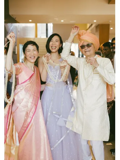 The joy of family in a cross-cultural wedding. This photo captures the happy celebration of the bride's family, embracing Indian traditions.