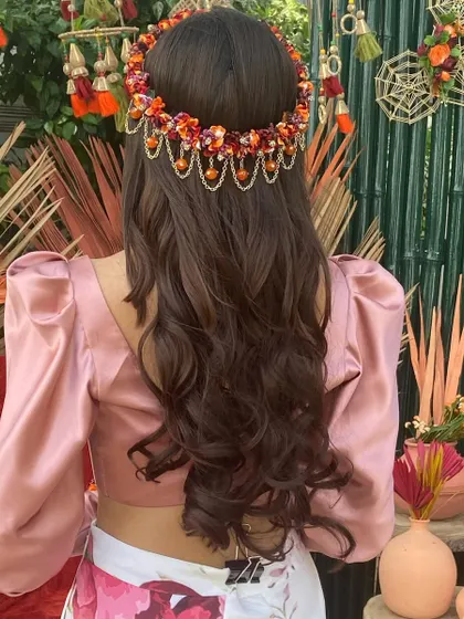 A beautiful Mehendi look featuring soft waves and a stunning floral and beaded headpiece.