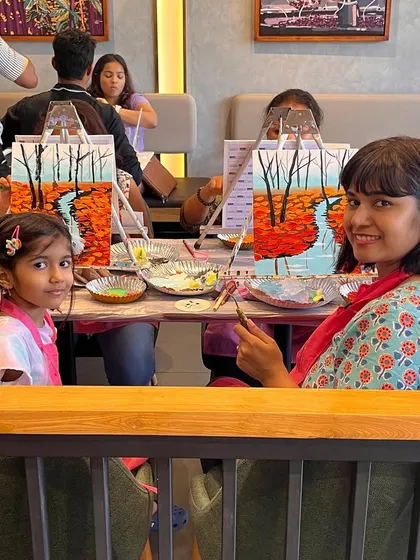 A mother and daughter painting together at a weekend workshop. It's a wonderful bonding experience for families.