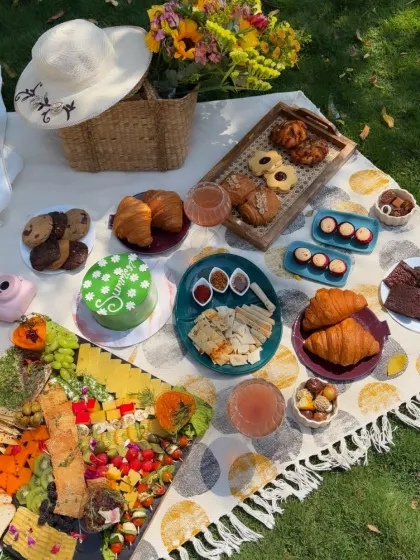 Our platter sits on a picnic blanket among pastries and other treats, bringing fruit and little bites into an outdoor spread.