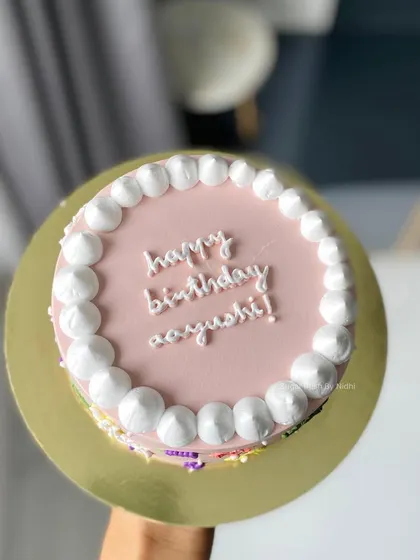 A simple and sweet pink cake with a pearl-like border. It's a classic design that's perfect for any birthday celebration.
