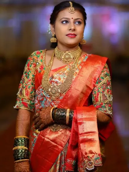 The rich colors of the hand embroidery on the blouse perfectly match the tones in her saree. It's these details that make a custom piece so special.