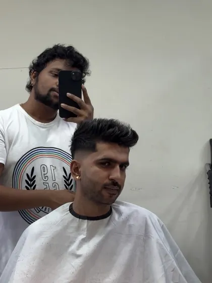 A mirror selfie showing a client with a fresh fade and textured top.