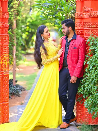 A sweet moment between the couple. The groom's red blazer is chosen to perfectly complement her bright yellow gown for a vibrant, coordinated look.