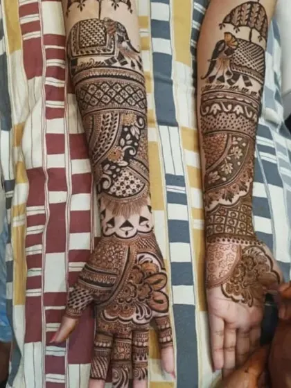 A full-arm design in progress, showing a mix of traditional elements like the baraat elephant and intricate paisley patterns.