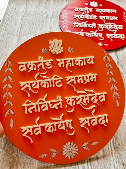 The orange version of the 'Vakratunda Mahakaya' hanging, perfect for adding a bright and positive touch to your walls.