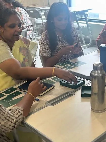 A close-up of teachers playing with the Yonjuu cards, showing their focus and engagement. The tactile nature of the cards is a key part of the learning experience.
