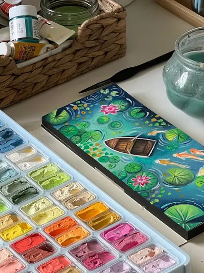 Another view of the gouache lily pond painting, showing the detail of the boat and the surrounding lily pads.