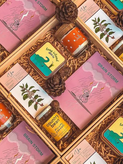 A flat lay of colorful and fun gift boxes. This curation is perfect for a young, energetic team, with items like flavored coffee, green tea, and quirky notebooks.