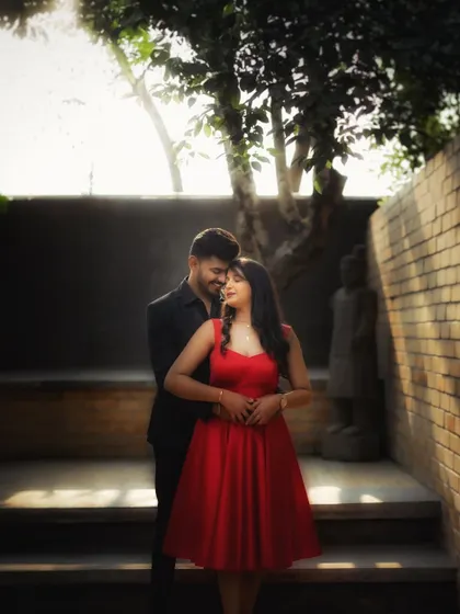 A romantic embrace against a rustic brick wall. The warm sunlight and contrasting textures create a beautiful, intimate setting for this couple's portrait.
