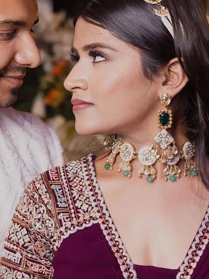 A close-up portrait capturing the loving gaze between a couple. We pay close attention to the details, from the bride's elegant jewelry to the intricate embroidery on her outfit.