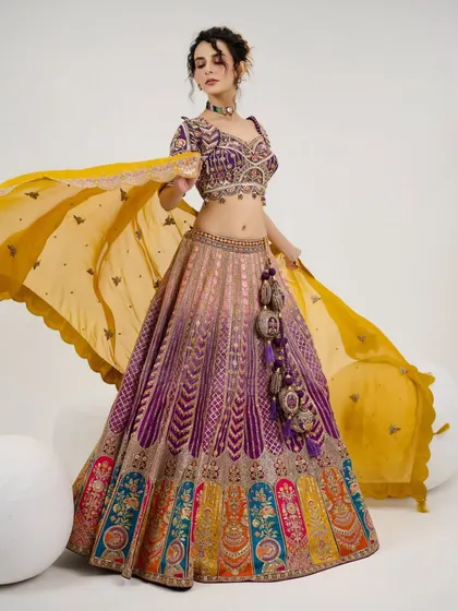 A full shot of the model in the multi-color lehenga, showing its unique design and vibrant colors.