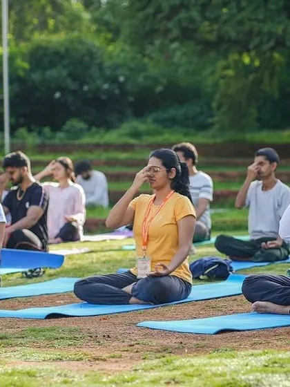 A group practices pranayama together outdoors. Group practice amplifies the energy and creates a supportive environment, making it easier to go deeper into the experience of breathwork for stress relief.