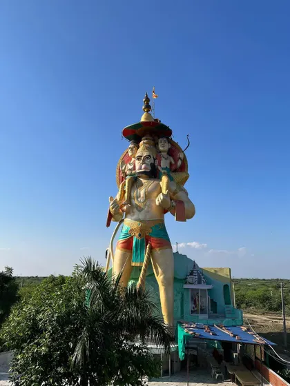 The Hanuman statue seen from the side, standing tall against the vast Rajasthani plains.