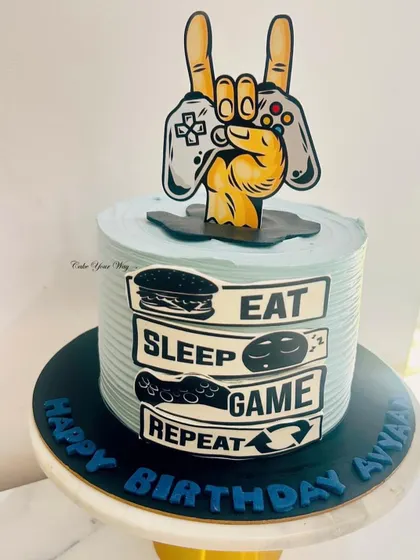 Eat, Sleep, Game, Repeat. This cake is for the ultimate gamer, featuring a controller and the gamer's life motto.