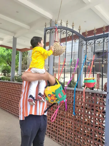 A father helps his son reach the Dahi Handi. We love when parents join our celebrations, making them a true community affair.