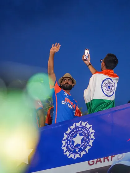 A photo series from the victory parade, capturing the Indian cricket team celebrating with the trophy on an open-top bus at Marine Drive. The images are filled with the joy and pride of the players and fans.