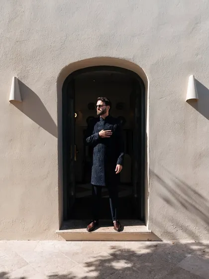 Groom styling is about creating a look that is strong and confident, yet complements the bride's attire. For this Sangeet in Spain, we styled the groom in a classic midnight blue achkan by Manish Malhotra, a timeless piece that stood out with quiet elegance.