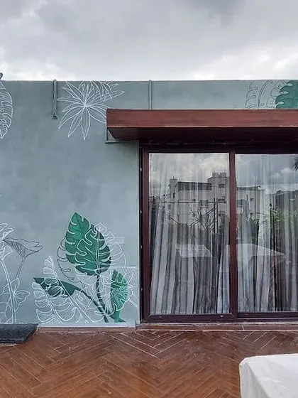 A minimalist and aesthetic take on a tropical theme. This graffiti art on a rooftop uses a mix of clean white line art and block-colored leaves to create a modern and stylish flora and fauna design.