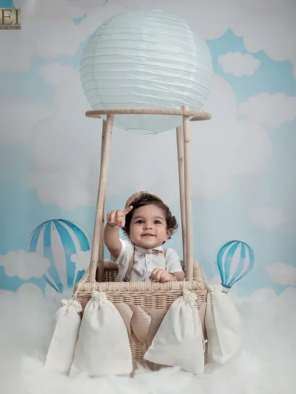 Waving from his hot air balloon, this baby is ready for a sky-high journey. These whimsical shots are perfect for capturing a sense of wonder and imagination.