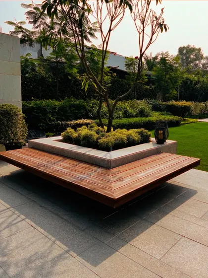 I designed this unique wrap-around wooden bench that incorporates a central planter. This piece of hardscaping is both a functional seating element and a beautiful focal point for the garden.