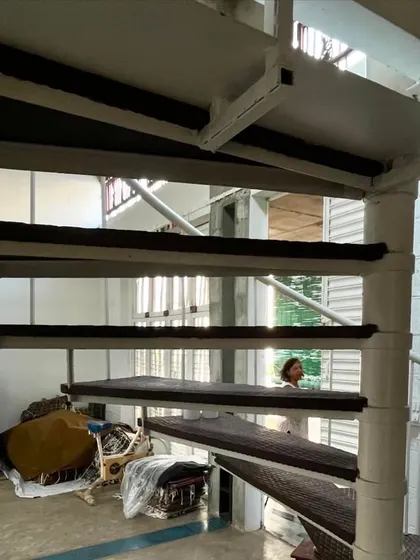 The white spiral staircase in the artist's studio is a light, sculptural element that connects the different levels of the workspace. Its open design allows light and views to filter through, maintaining a sense of spaciousness.