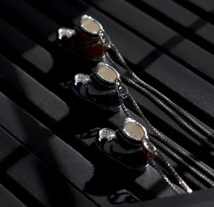 A close-up shot of the colorful sneaker pendants, using specific lighting to highlight the enamel details on each piece against a textured, dark background.
