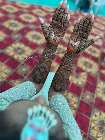 An overhead shot capturing the full extent of the bridal mehndi. This angle shows the design from the fingertips to the elbows, highlighting the detailed portrait work on the palms.