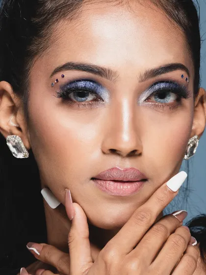 A close-up beauty shot showcasing a smoky blue eye with small gem details. This highlights my skill in capturing intricate makeup details for beauty portfolios.