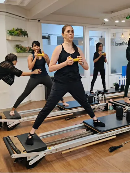 Various shots of members and instructors in action during our dynamic Reformer Pilates classes.