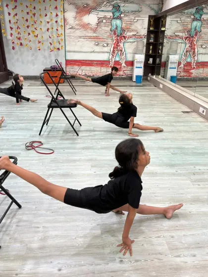 A young dancer holds a perfect split, showcasing the amazing progress our students make in our contemporary program.
