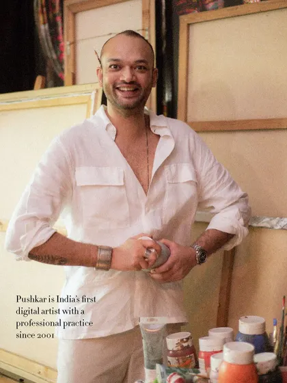 A happy, candid portrait of artist Pushkar Thakur in his studio. His smile and the creative chaos around him perfectly capture his vibrant energy.