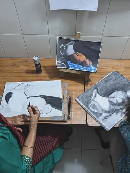 An overhead view of two adult students working on their art. This shows the focused environment we cultivate, allowing each person to immerse themselves in their creative process.