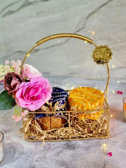 A closer look at my festive golden basket hamper. This option includes two jars of my tea cakes, adorned with traditional Bandhani and Bandhej fabric tops, and a 'Shubh Diwali' tag for that perfect festive touch.