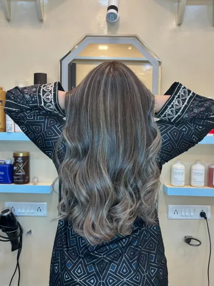 From the back, you can see the full effect of the balayage. The highlights are placed strategically to create a natural, sun-kissed effect with soft, healthy waves.