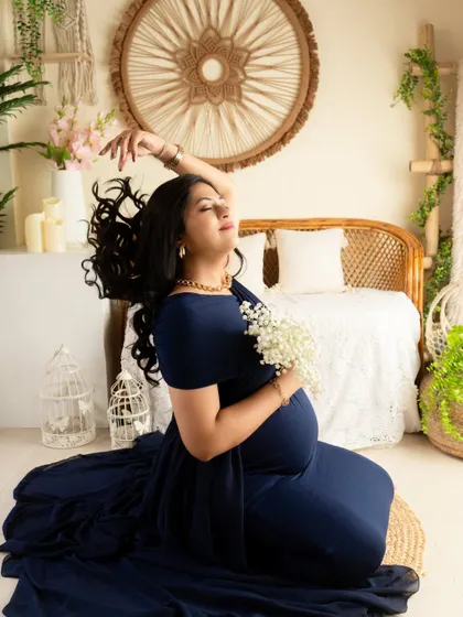 A dynamic pose with a hair flip, capturing movement and energy. The navy blue gown looks stunning in this expressive, seated portrait.