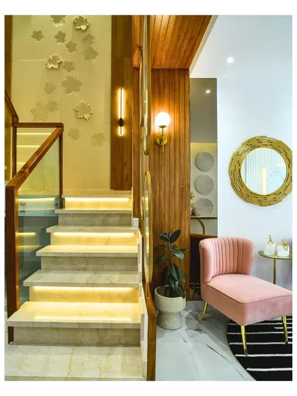 This image captures the dual nature of light in design. The illuminated staircase steps provide functional safety, while the decorative wall sconces and warm light on the wood panels create a beautiful, ambient glow.