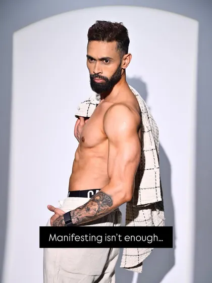 A confident pose with an unbuttoned shirt, captioned "Manifesting isn't enough." This reinforces my philosophy that action is what creates results.