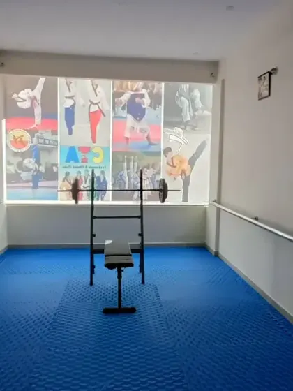 A dedicated area for strength and conditioning, equipped with weights and a bench press.