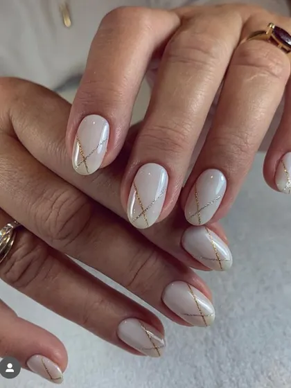 A sophisticated and elegant design for a wedding or special event. A milky white base is adorned with delicate, intersecting lines of gold and silver glitter.