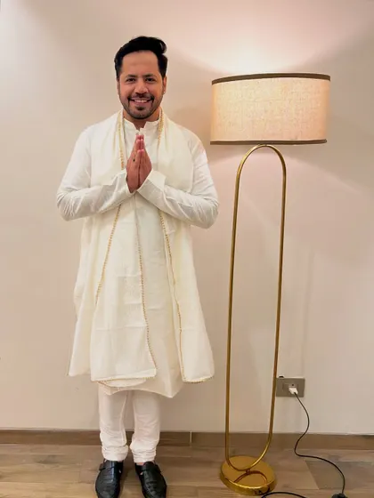 A respectful 'Namaste' pose in the white kurta. This is perfect for welcoming guests or opening a traditional event.