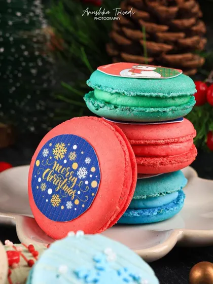 A detailed shot focusing on the "Merry Christmas" macaron, making it the hero of the festive stack.