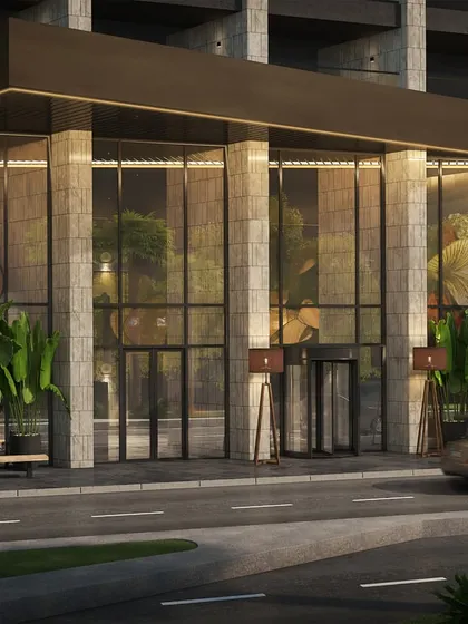 The modern entrance of the Pullman Hotel in the Middle East. This ground-level exterior view focuses on the sleek glass facade and welcoming entryway, designed to convey a sense of luxury and hospitality.