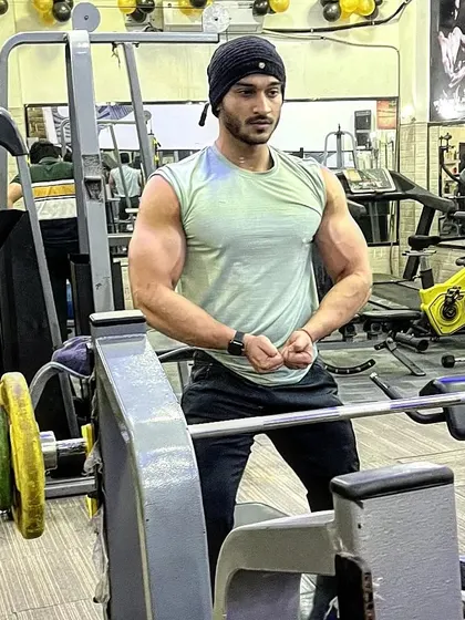 Muscular biceps. A strong pose in the gym.
