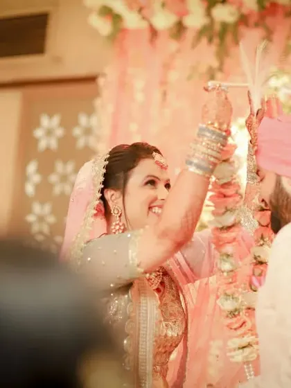 A lovely, warm-toned photo of the Jaimala ceremony. The soft focus on the guests allows the happy couple to be the center of attention.