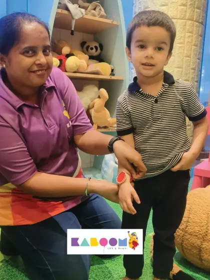 A staff member helps a young boy with his Rakhi during our Rakshabandhan celebration. We make sure every child feels included in the festive fun.