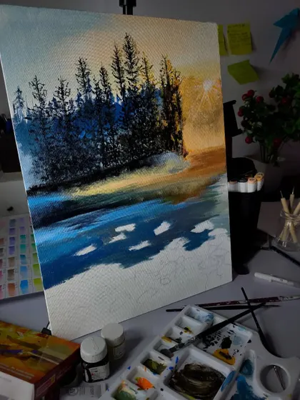 A work-in-progress shot of an acrylic landscape on canvas. I'm building up the treeline against a warm sunset sky, using fine brushes for the detailed tree silhouettes.
